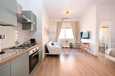 a kitchen and living room with a stove top oven at Cozy Studio Steps from Metro station in Rome