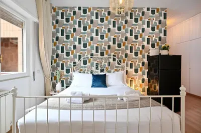 a bedroom with a bed with a large headboard at Cozy Studio Steps from Metro station in Rome