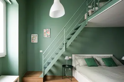 a bedroom with green walls and a bed with a staircase at New lovely apartment near the metro A in Rome