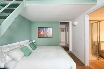 a bedroom with a white bed with a blue wall at New lovely apartment near the metro A in Rome