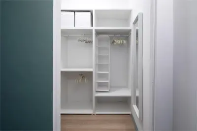 a white walk in closet with white shelves at New lovely apartment near the metro A in Rome