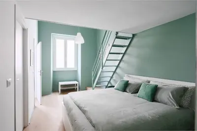 a bedroom with a bed with green walls and a staircase at New lovely apartment near the metro A in Rome