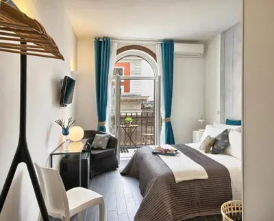 a bedroom with a bed and a chair and a window at Relais Quattro Fontane in Rome