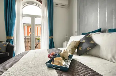 a bed with a tray with cups and flowers on it at Relais Quattro Fontane in Rome