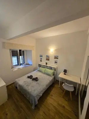 a small bedroom with a bed and a desk at Casa in Rome