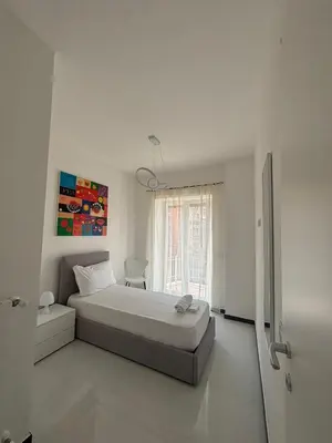 a white bedroom with a bed and a window at 612 Flats in Rome