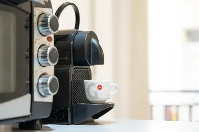 a microwave oven with a coffee cup on a counter at Piazza Cavour Apartment 90 in Rome
