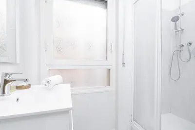 a white bathroom with a sink and a shower at Piazza Cavour Apartment 90 in Rome