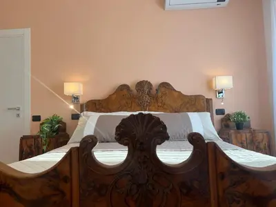 a large wooden bed in a bedroom with two lamps at ARTPA Rome Apartments Gianicolo, Roma in Rome