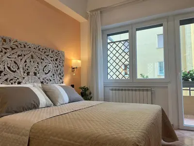 a bedroom with a large bed with a large window at ARTPA Rome Apartments Gianicolo, Roma in Rome