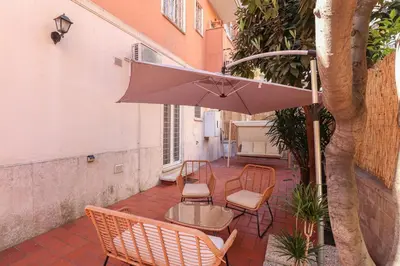 a patio with a table and chairs and an umbrella at Oasi di relax a Monteverde in Rome