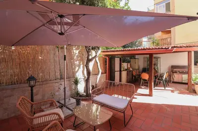 a patio with a table and chairs and an umbrella at Oasi di relax a Monteverde in Rome
