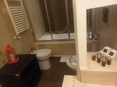 a bathroom with a toilet and a glass shower at StefanoHouse Barberini 2 appartamenti in Rome
