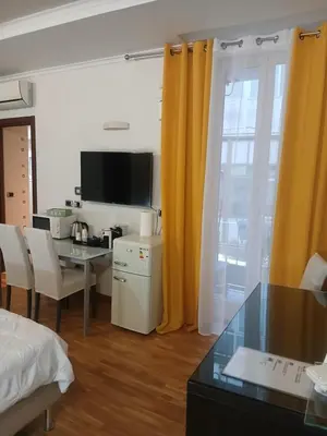 a room with a bed and a desk and a television at StefanoHouse Barberini 2 appartamenti in Rome