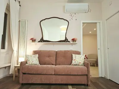 a living room with a brown couch and a mirror at Melli's R-Home in Rome