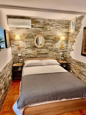 a bedroom with a bed and a stone wall at Vatican Staircase in Rome
