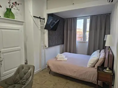 a bedroom with a bed and a window and a chair at Piccola Domus in Rome