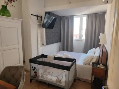 a bedroom with a bed and a tv on the wall at Piccola Domus in Rome