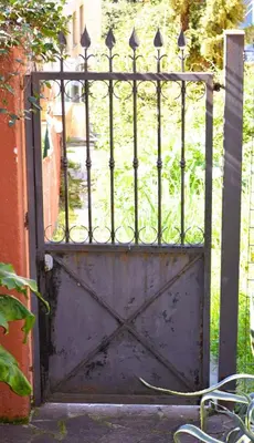 an old metal gate with an open door at A casa di Cicca in Rome
