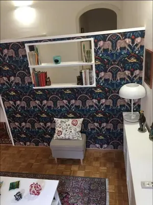 a room with a chair and a shelf with books at Diana's Loft in Rome
