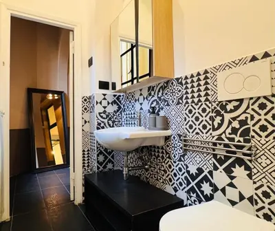a bathroom with a sink and black and white tiles at Loft Penta - apartment Colosseum in Rome