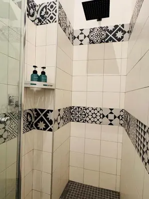 a bathroom with a shower with black and white tiles at Loft Penta - apartment Colosseum in Rome