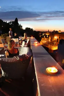 a group of people sitting on a ledge on a roof at Loft Penta - apartment Colosseum in Rome
