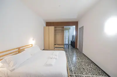 a bedroom with a white bed and a hallway at Spacious and Bright 3BR Family Apartment in Rome