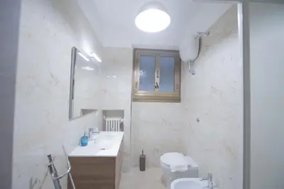 a bathroom with a sink and a toilet and a mirror at Spacious and Bright 3BR Family Apartment in Rome
