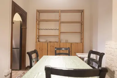a dining room with a table and chairs and a shelf at Spacious and Bright 3BR Family Apartment in Rome