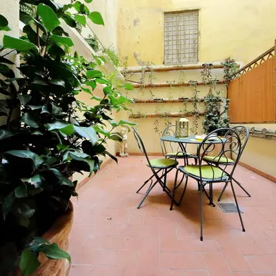 a patio with a table and chairs and a plant at Il patio al Colosseo in Rome