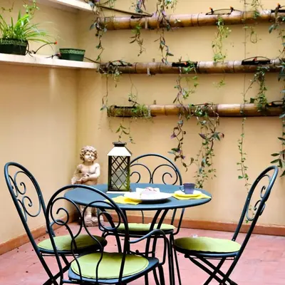 a table and chairs in a patio with plants at Il patio al Colosseo in Rome