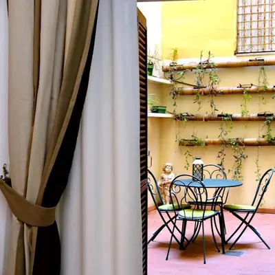 a table and chairs next to a curtain at Il patio al Colosseo in Rome