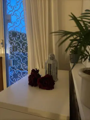 a table with roses and a candle on it at 4M Apartment in Rome