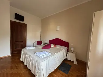 a bedroom with a bed with white sheets and red pillows at 4M Apartment in Rome
