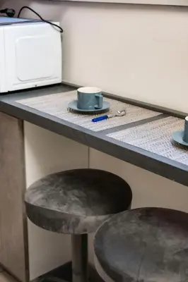 a counter with two cups and a stool next to a microwave at Maison Monteverde, Trastevere in Rome