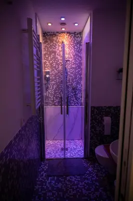 a bathroom with a shower with purple lighting at Maison Monteverde, Trastevere in Rome