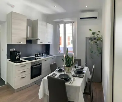 a kitchen with a table with chairs and a kitchen with white cabinets at San Lorenzo Elegance Suites - just steps from the Colosseum in Rome