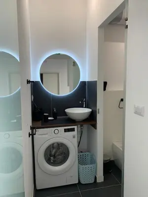 a bathroom with a washing machine and a sink at San Lorenzo Elegance Suites - just steps from the Colosseum in Rome