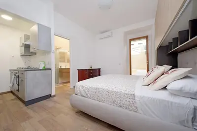a white bedroom with a bed and a sink at Monica's house in Rome