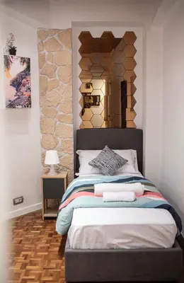 a bedroom with a bed with a stone wall at Lusitiny Apartment in Rome
