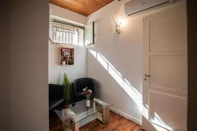 a hallway with a door and a chair and a table at Lusitiny Apartment in Rome