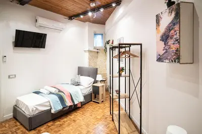a bedroom with a bed and a tv on a wall at Lusitiny Apartment in Rome