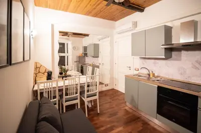 a kitchen and living room with a table and a counter at Lusitiny Apartment in Rome