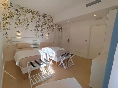 a bedroom with two beds and a wall with flowers at La Casa di MiDa in Rome