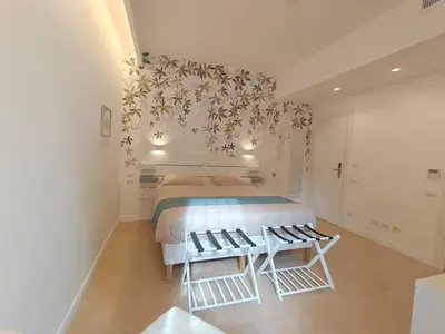 a white bedroom with a bed and two chairs at La Casa di MiDa in Rome