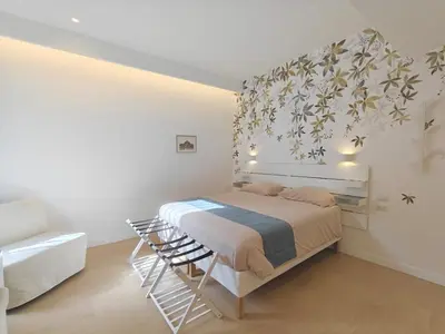 a white bedroom with a bed and a chair at La Casa di MiDa in Rome