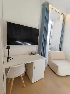 a room with a desk with a bed and a tv at La Casa di MiDa in Rome