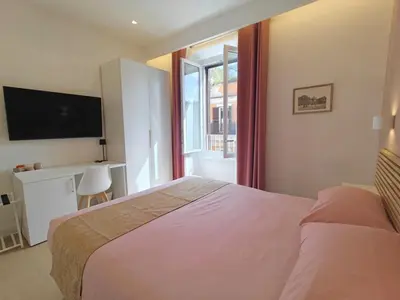 a bedroom with a bed and a tv and a window at La Casa di MiDa in Rome