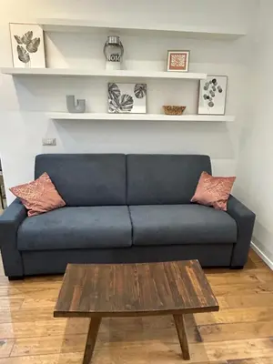a blue couch with a coffee table in a living room at Benny's House Rome in Rome